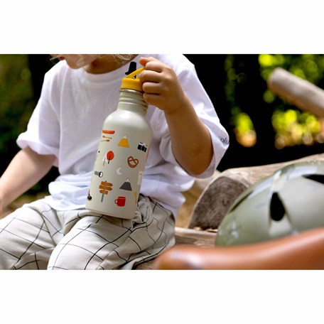 Kind sitzend mit Trinkflasche in der Hand