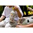 Kind sitzend mit Trinkflasche in der Hand