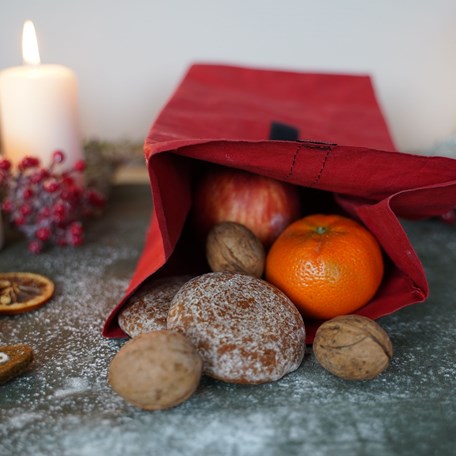 Brotzeitbeutel gefüllt mit Obst Nüssen in weihnachtlichem Setting