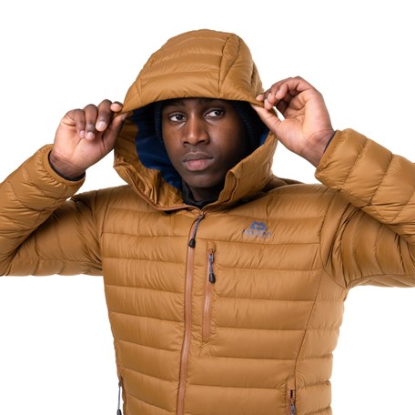 Mann mit gelbbrauner Daunenjacke mit Kapuze auf
